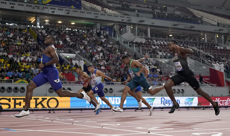 Christian Coleman, of the United States, crosses the line ahead of Aaron Brown, of Canada, and Adam Gemili, of Great Britain, in a men's 100 meter semifinal at the World Athletics Championships in Doha, Qatar, Saturday, Sept. 28, 2019. (AP Photo/David J. Phillip)