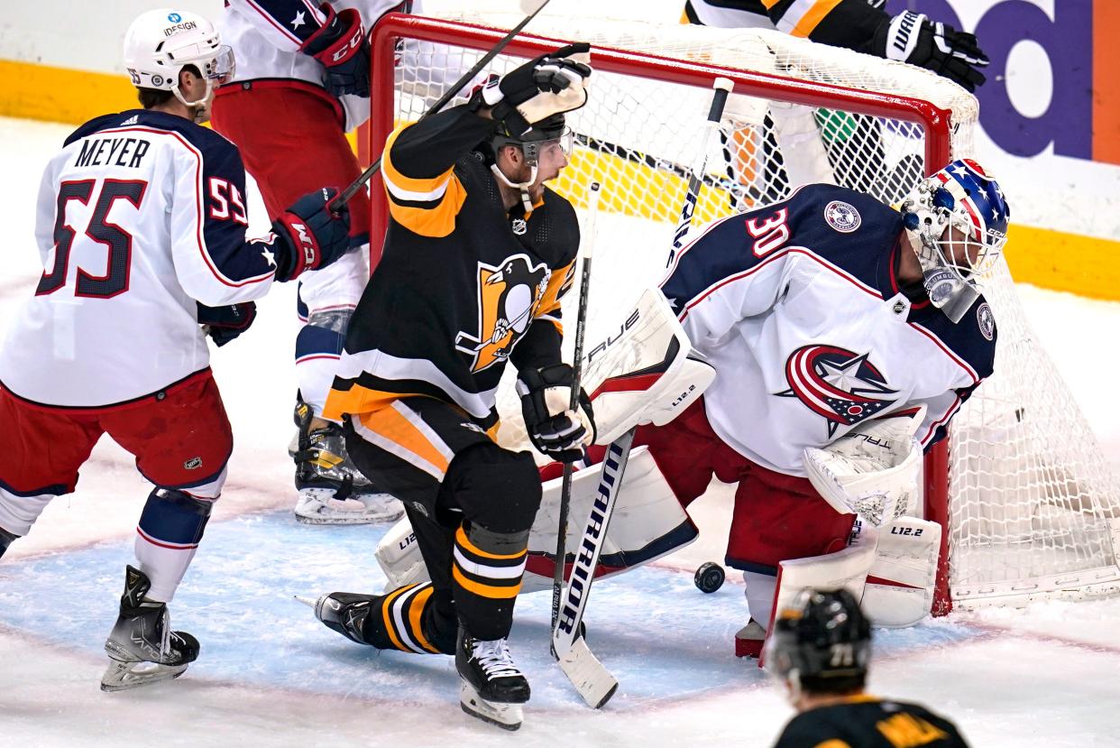 Pittsburgh Penguins' Marcus Pettersson, center, celebrates his goal past Columbus Blue Jackets goaltender J-F Berube (30) withBlue Jackets' Carson Meyer (55) defending during the first period of an NHL hockey game in Pittsburgh, Friday, April 29, 2022. (AP Photo/Gene J. Puskar)