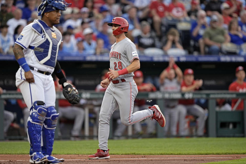 Cincinnati Reds' Kevin Newman (28) runs home past Kansas City Royals catcher Salvador Perez to score on single by TJ Friedl during the second inning of a baseball game Tuesday, June 13, 2023, in Kansas City, Mo. (AP Photo/Charlie Riedel)