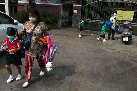 Students and their parents wear masks outside a public school, as classes in over 400 Bangkok schools have been cancelled due to worsening air pollution, in Bangkok, Thailand, January 30, 2019. REUTERS/Athit Perawongmetha