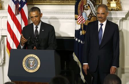 President Obama (L) announces the resignation of Attorney General Eric Holder in the White House State Dining Room, September 25, 2014. REUTERS/Larry Downing