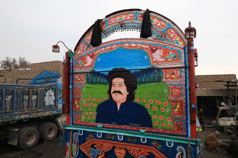 A decorated supply truck with a portrait of Ali Wazir, a politician from South Waziristan, is seen parked in a workshop in Peshawar