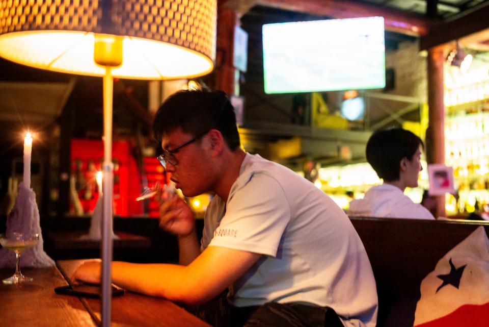 A man smoking indoors in the bar area of ​​Shichahai in Beijing in 2019.