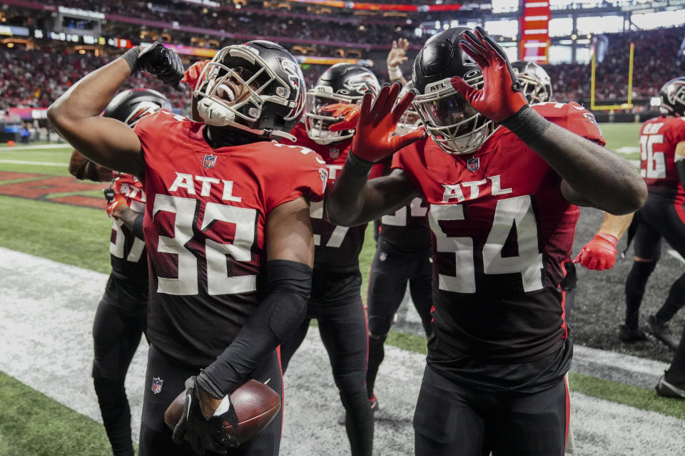 Atlanta Falcons players celebrate with Atlanta Falcons safety Jaylinn Hawkins (32) after Hawkins picked the ball from Chicago Bears quarterback Justin Fields after an NFL football game, Sunday, Nov. 20, 2022, in Atlanta. The Atlanta Falcons won 27-24. (AP Photo/John Bazemore)