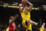 Iowa center Luka Garza (55) grabs a rebound over Nebraska guard Dachon Burke Jr., left, during the first half of an NCAA college basketball game, Saturday, Feb. 8, 2020, in Iowa City, Iowa. (AP Photo/Charlie Neibergall)