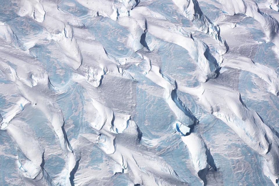 <p>Patterns of ice and blue ice are seen from NASA’s Operation IceBridge research aircraft, in the Antarctic Peninsula region on Oct. 31, 2017, above Antarctica. (Photo: Mario Tama/Getty Images) </p>