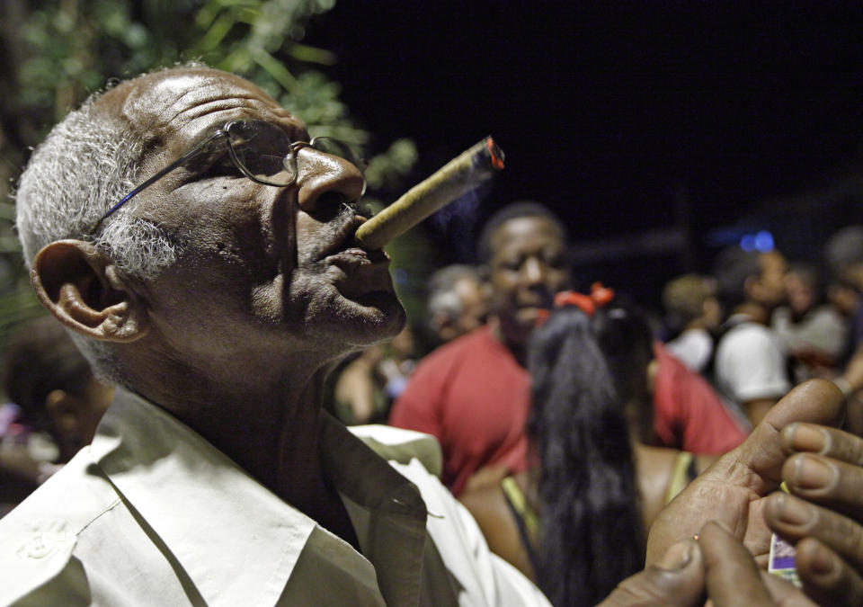 In this picture taken on April 25, 2012, a man puffs on his cigar during a meeting of a CDR or Committee for the Defense of the Revolution at a neighborhood in Santiago de Cuba, Cuba. (AP Photo/Kathy Willens)