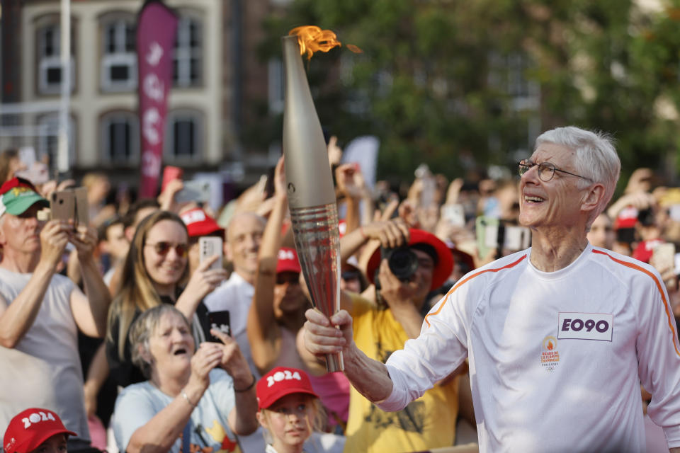 Arsene Wenger carries the Olympic torch Wednesday, June 26, 2024 in Strasbourg, eastern France. The Paris 2024 Olympic Games will run from July 26 to Aug.11, 2024. (AP Photo/Jean-Francois Badias)