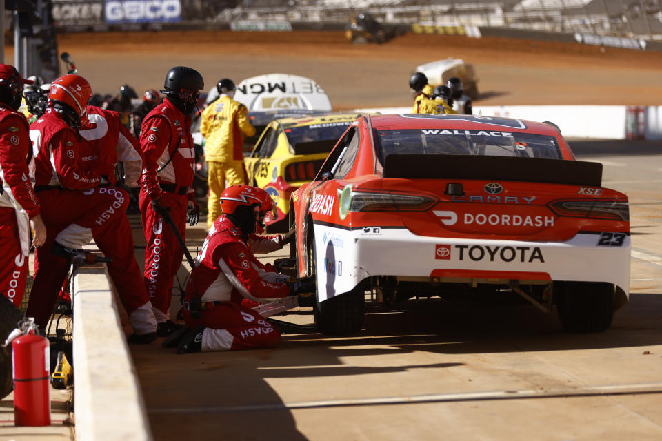 Member of the pit crew for driver Bubba Wallace (23) work on his car during a competition caution of a NASCAR Cup Series auto race, Monday, March 29, 2021, in Bristol, Tenn. (AP Photo/Wade Payne)