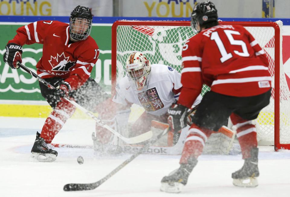 Canada's Connor McDavid (L) makes a pass to Canada's Derrick Pouliot in front of Czech Republic's goalie Marek Langhammer during the first period of their IIHF World Junior Championship ice hockey game in Malmo, Sweden, December 28, 2013. REUTERS/Alexander Demianchuk (SWEDEN - Tags: SPORT ICE HOCKEY)