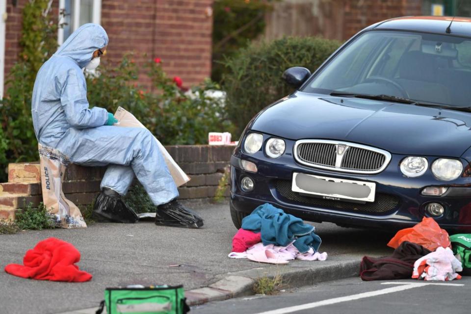 Forensics officers inspect the scene of the attack in south-east London (PA)