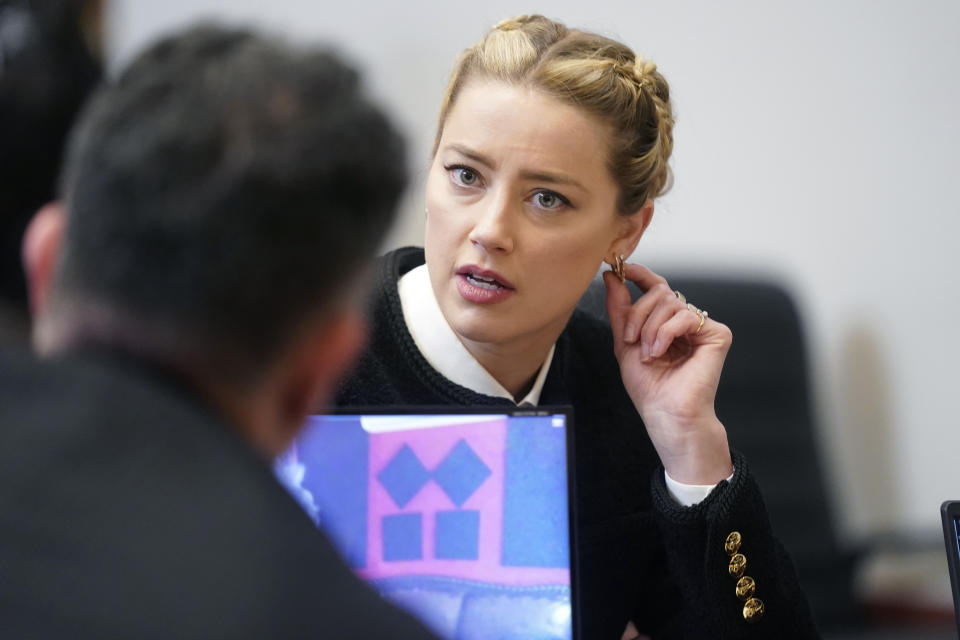 La actriz Amber Heard habla con un miembro de su equipo legal en el Tribunal de Circuito del Condado de Fairfax, el jueves 19 de mayo de 2022 en Fairfax, Virginia. (Shawn Thew/Pool Photo via AP)