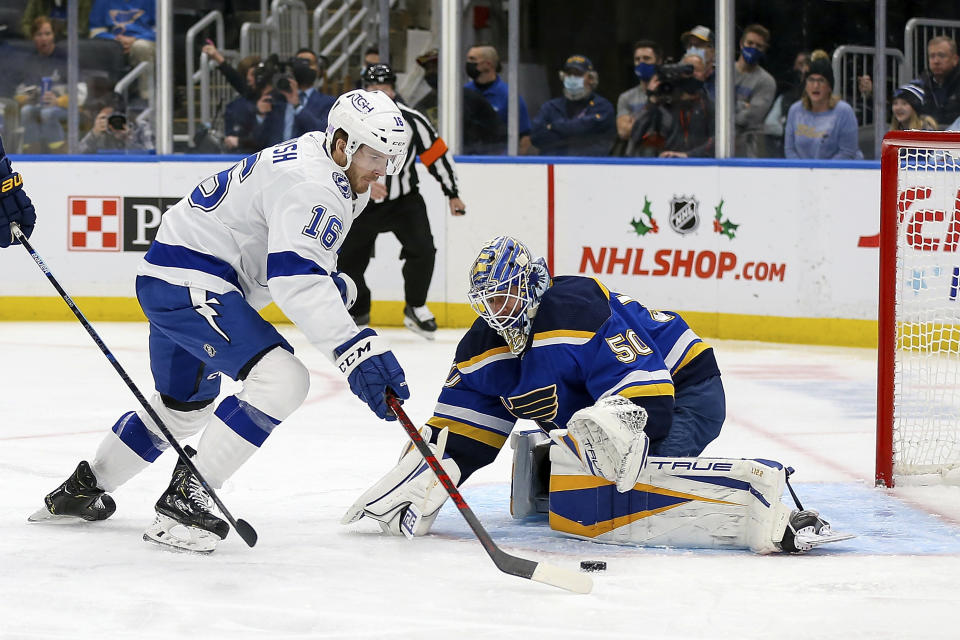 St. Louis Blues goaltender Jordan Binnington (50) defeats the goal against Tampa Bay Lightning's Taylor Raddysh (16) during the first period of an NHL hockey game Tuesday, Nov. 30, 2021, in St. Louis. (AP Photo/Scott Kane)