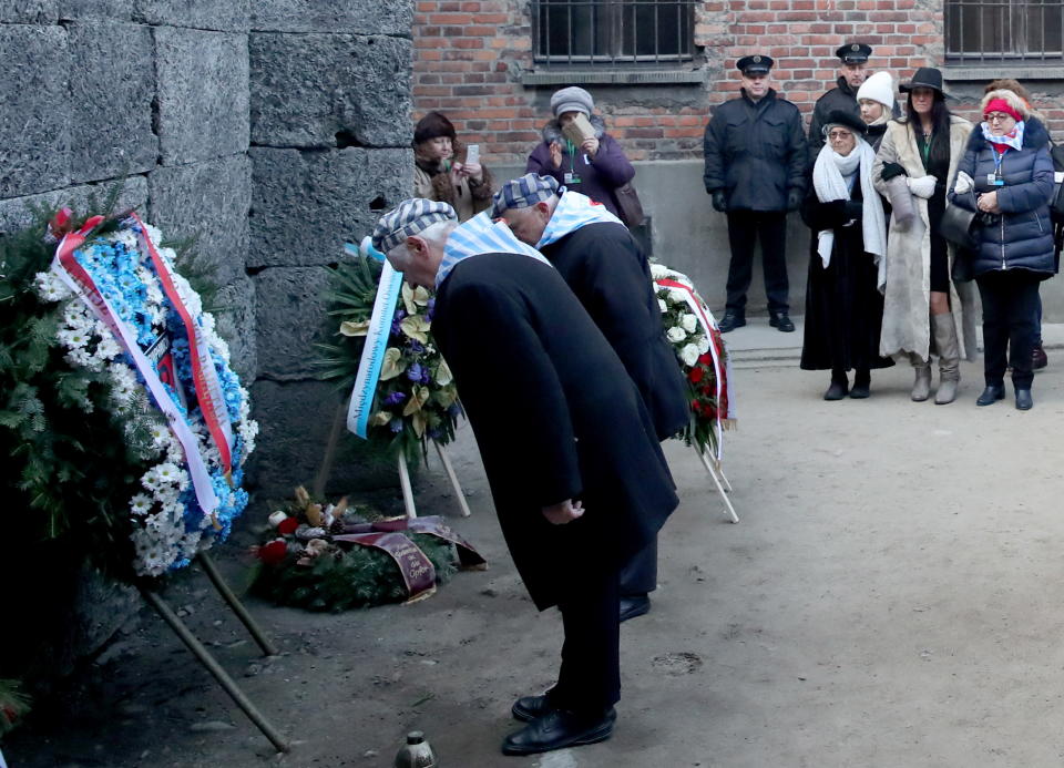 Survivors lay wreaths and flowers at the Wall of Death, where the SS shot several thousand people.