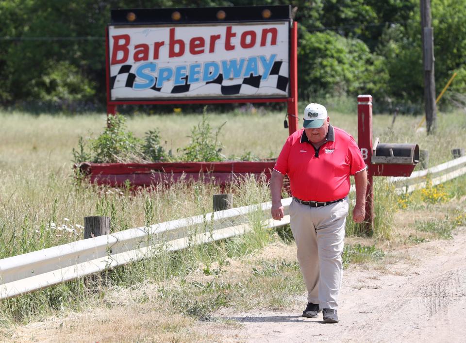 Steve Brookens, who worked at the Barberton Speedway for 47 years, walks back to his car after taking a photo of the sign on Clark Mill Road.