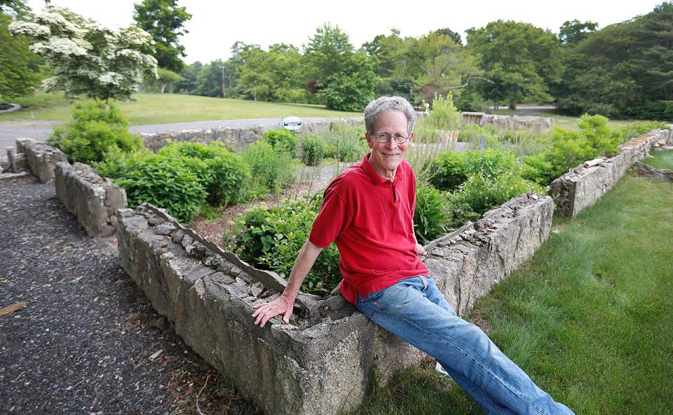 Sam Chapin sits on the foundation of the original two-story dairy barn at the Davis-Douglas Farm in Plymouth.