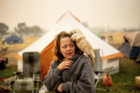 <p>Suzanne Kaksonen, an evacuee of the Camp Fire, and her cockatoo Buddy camp at a makeshift shelter outside a Walmart store in Chico, Calif., on ov. 14, 2018. Kaksonen lost her Paradise home in the blaze. (Photo: Noah Berger/AP) </p>