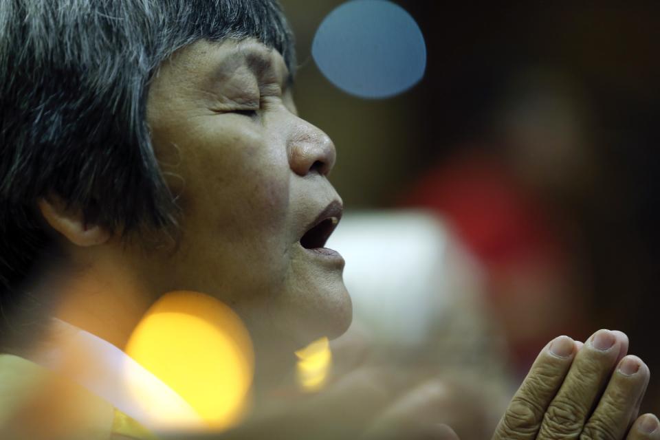 A woman takes part in a special prayer for passengers onboard the missing Malaysia Airlines flight MH370 at the MCA headquarters in Kuala Lumpur