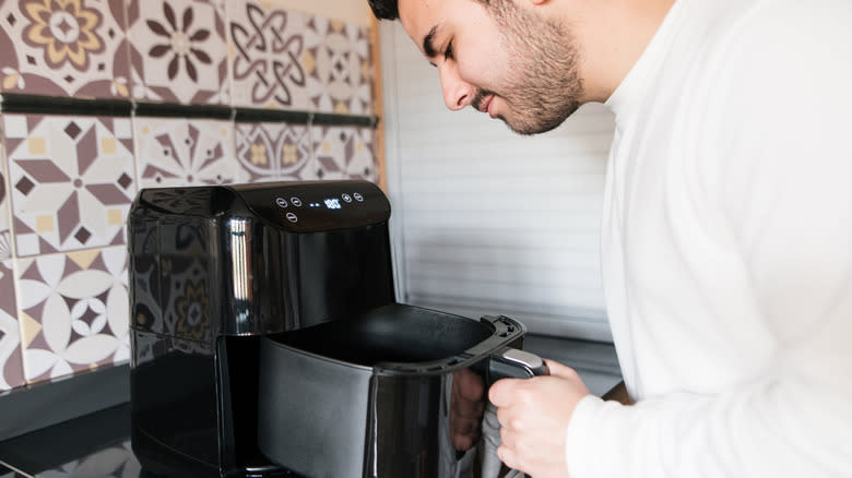 man checking air fryer