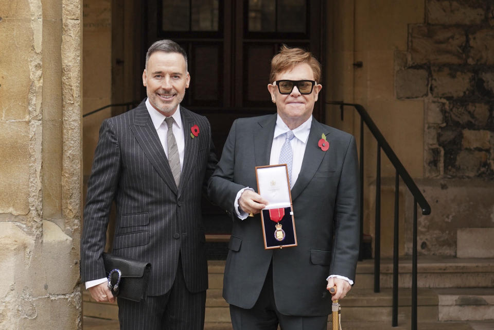 Sir Elton John, con su esposo David Furnish, después de ser nombrado miembro de la Orden de los Compañeros de Honor por sus servicios a la música y a la caridad durante una ceremonia de investidura en el Castillo de Windsor, en Windsor, Inglaterra, el miércoles 10 de noviembre de 2021. (Dominic Lipinski/Pool photo via AP)