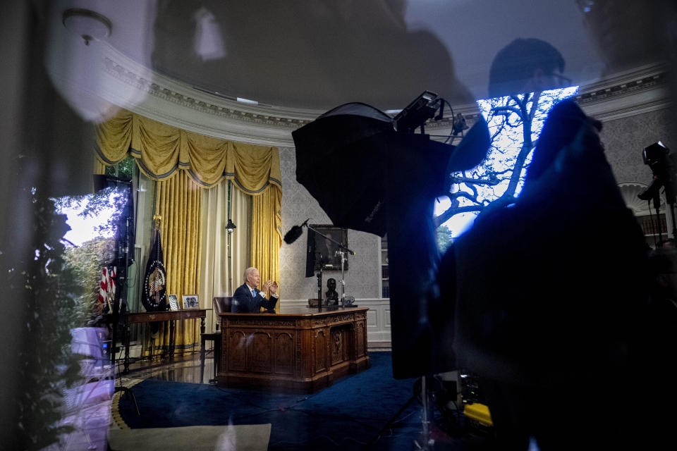 Seen through a window, President Joe Biden addresses the nation on the budget deal that lifts the federal debt limit and averts a U.S. government default, from the Oval Office of the White House in Washington, Friday, June 2, 2023. (AP Photo/Andrew Harnik)