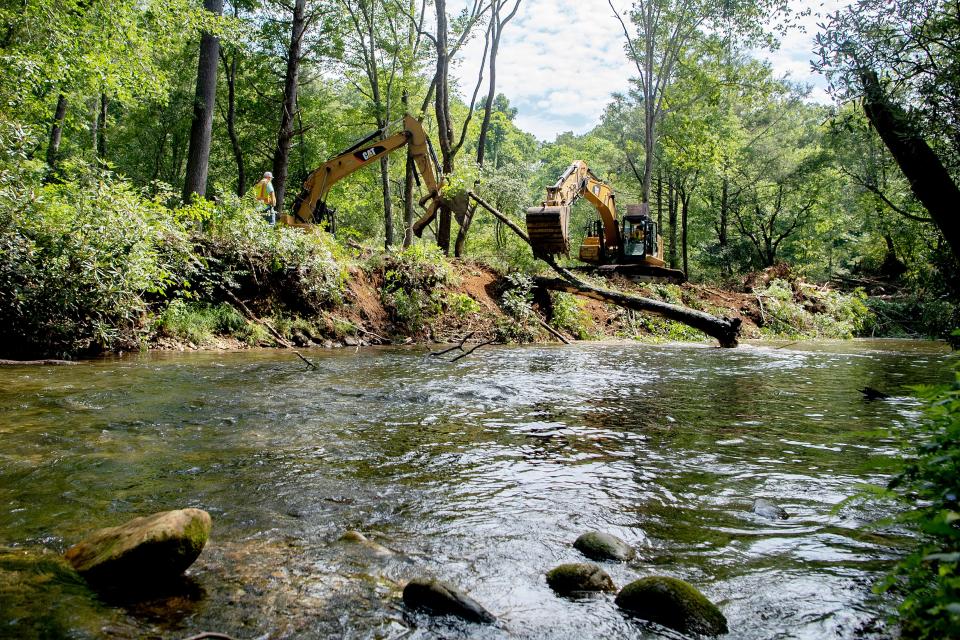 A crew from North State Environmental uses excavators to move trees and dirt from the riverbank of the Davidson River downstream from the Setzer State Fish Hatchery in the Pisgah National Forest on Aug. 5, 2020.