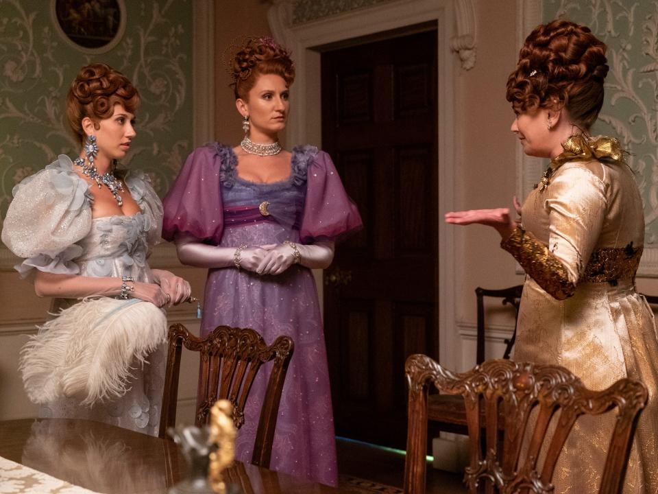 philipa featherington and prudence featherington, young women with red hair and blue and purple gowns, speaking with their mother lady featherington in a dining room