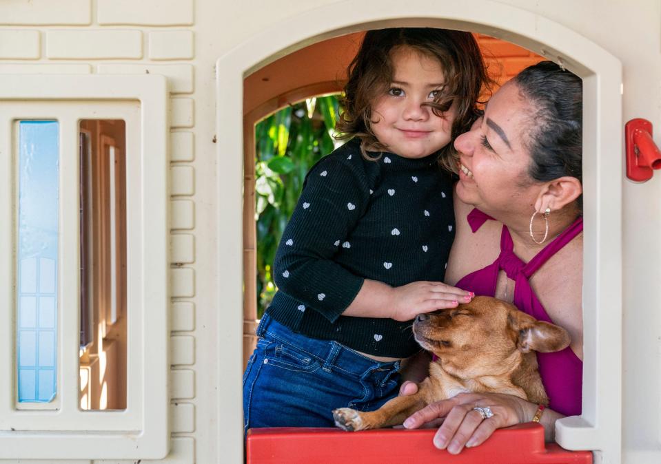 Amy Galeano, 3, with her mother, Karina Casteneda and their dog, Sky at their home in Lake Worth Beach.