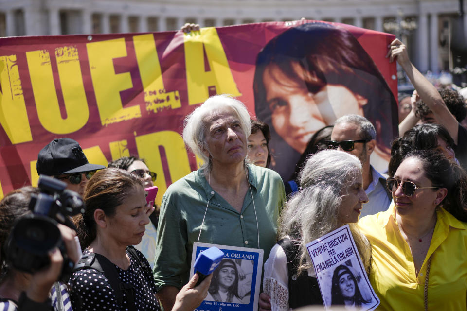 Pietro Orlandi, center, wears a placard with a picture of his sister Emanuela during a sit-in in St.Peter's Square as Pope Francis recites the Angelus noon prayer, at the Vatican, Sunday, June 25, 2023. The Pope in his speech remembered the 40th anniversary of the disappearance of Emanuela Orlandi, the 15-year-old daughter of a lay employee of the Holy See, that vanished June 22, 1983, after leaving her family's Vatican City apartment to go to a music lesson in Rome. (AP Photo/Andrew Medichini)