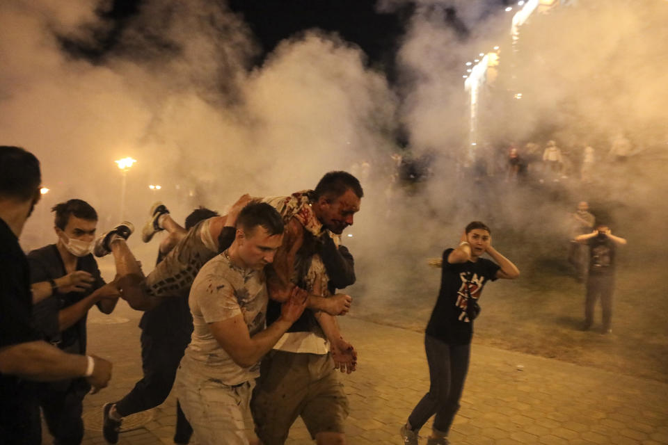 FILE - In this Aug. 10, 2020, file photo, protesters carry a wounded man during clashes with police after the presidential election in Minsk, Belarus. The diversion of a Ryanair flight to Lithuania by Belarus, leading to the arrest of Raman Pratasevich, an opposition journalist who was a passenger, has sparked international outrage and calls for tough sanctions against the former Soviet nation. Pratasevich ran a popular messaging app that helped organize the demonstrations. (AP Photo/File)