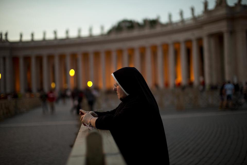 A nun prays in St. Peter's Square at the Vatican, Friday, April 25, 2014. Hundred thousands of pilgrims and faithful are expected to reach Rome to attend the scheduled April 27 ceremony at the Vatican in which Pope Francis will elevate in a solemn ceremony John XXIII and John Paul II to sainthood. (AP Photo/Emilio Morenatti)