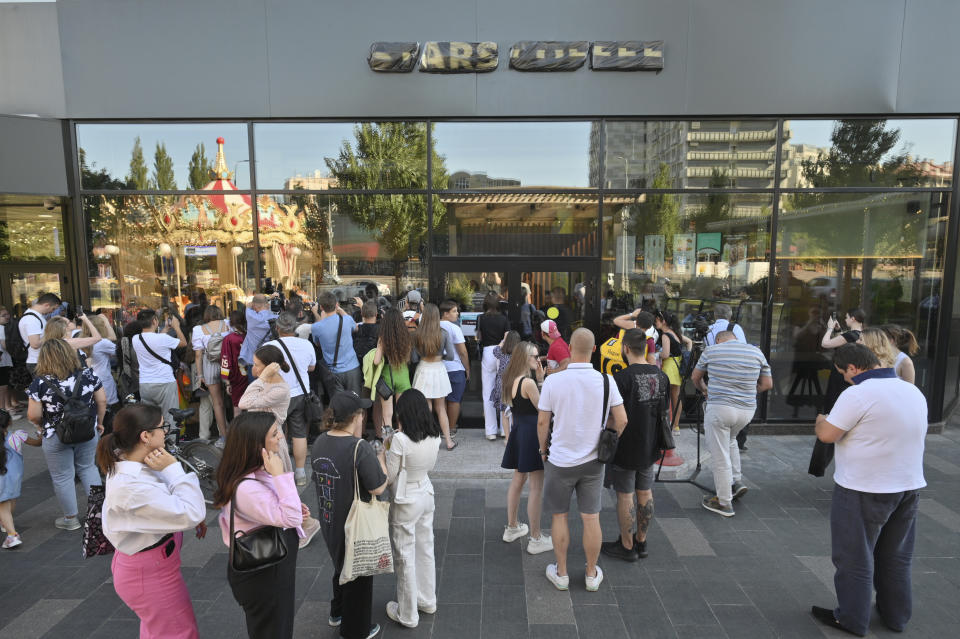 People gather to visit a newly opened Stars Coffee coffee shop in the former location of the Starbucks coffee shop in Moscow, Russia, Thursday, Aug. 18, 2022. A new chain of coffee shops opens Thursday in Moscow, after Russian singer and entrepreneur Timur Yunusov, better known as Timati, together with Russian restaurateur Anton Pinskiy bought the Starbucks stores following company's withdrawal from Russia. (AP Photo/Dmitry Serebryakov)