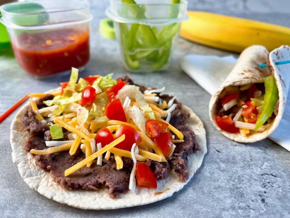 Spread low-fat or vegetarian refried beans on a street-taco-size soft flour tortilla. Add a sprinkling of grated Mexican cheese, shredded lettuce, and diced tomato and roll up.