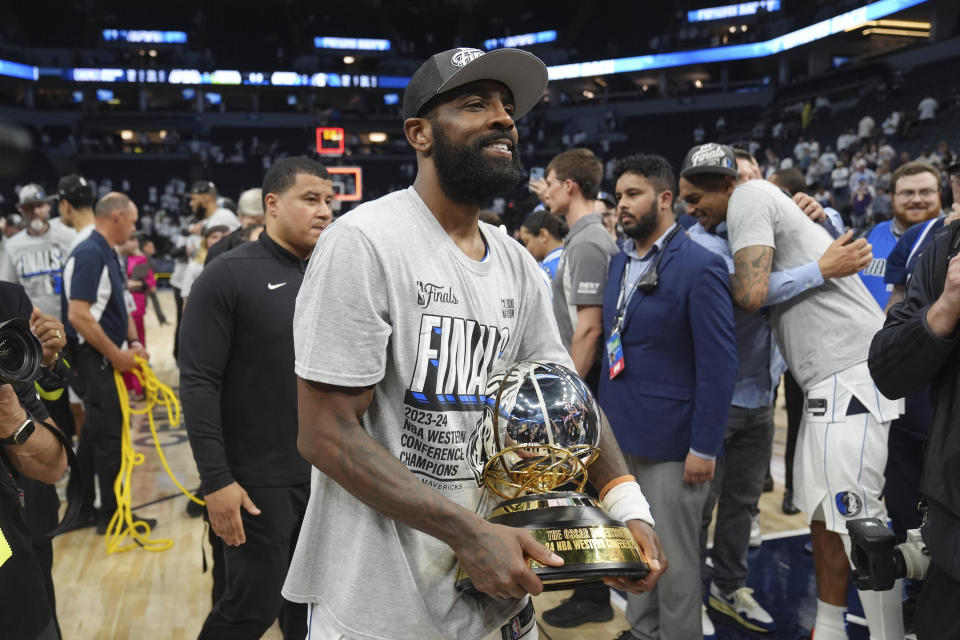 Dallas Mavericks guard Kyrie Irving holds the Western Conference Trophy after Game 5 of the Western Conference finals in the NBA basketball playoffs against the Minnesota Timberwolves, Thursday, May 30, 2024, in Minneapolis. The Mavericks won 124-103, taking the series 4-1 and moving on to the NBA Finals. (AP Photo/Abbie Parr)