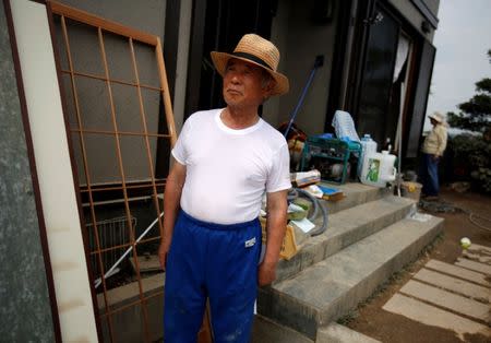 79-year-old local resident Isao Akutagawa, pauses as he tries to remove mud and debris from his house in a flood affected area in Mabi town in Kurashiki, Okayama Prefecture, Japan, July 12, 2018. REUTERS/Issei Kato