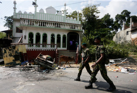 Sri Lanka's Special Task Force soldiers walk past a damaged mosque after a clash between two communities in Digana, central district of Kandy, Sri Lanka March 8, 2018. REUTERS/Dinuka Liyanawatte/File Photo