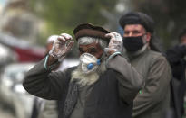 FILE - In this April 20, 2020, photo, daily-wage workers wear protective face mask to help curb the spread of the coronavirus in Kabul, Afghanistan. A prominent international aid organization warned Tuesday, June 2, 2020 that Afghanistan is on the brink of a humanitarian disaster because the government is unable to test at least 80% of possible coronavirus cases. (AP Photo/Rahmat Gul, File)