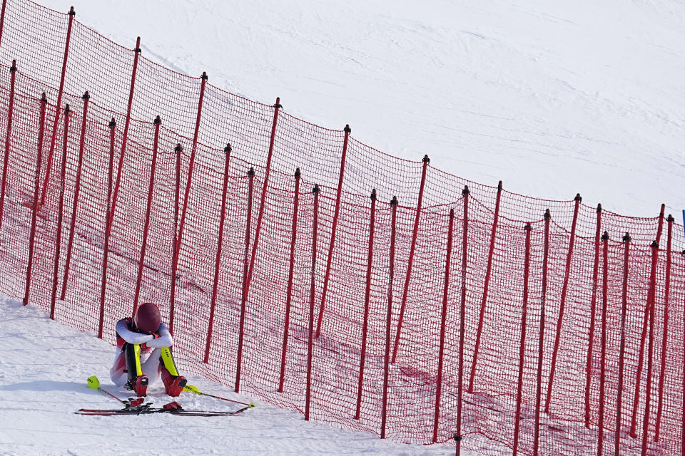 Mikaela Shiffrin, of the United States sits on the side of the course after skiing out in the first run of the women's slalom at the 2022 Winter Olympics, Wednesday, Feb. 9, 2022, in the Yanqing district of Beijing. (AP Photo/Robert F. Bukaty)