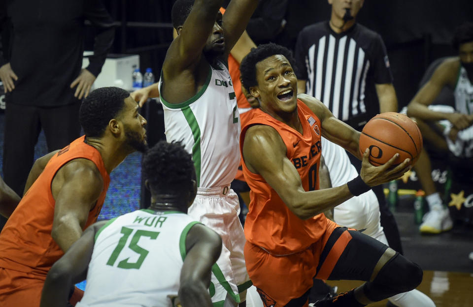 Oregon State guard Gianni Hunt (0) drives to the basket past Oregon forward Eugene Omoruyi (2) during the first half of an NCAA college basketball game Saturday, Jan. 23, 2021, in Eugene, Ore. (AP Photo/Andy Nelson)