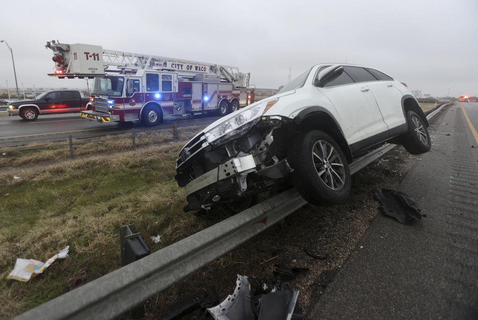 A vehicle rests on a barricade as the driver lost control and slid off Highway 6 on Tuesday Jan. 31, 2023 in Waco, Texas. Winter weather brought ice to Texas and nearby states Tuesday. (Jerry Larson/Waco Tribune-Herald via AP)