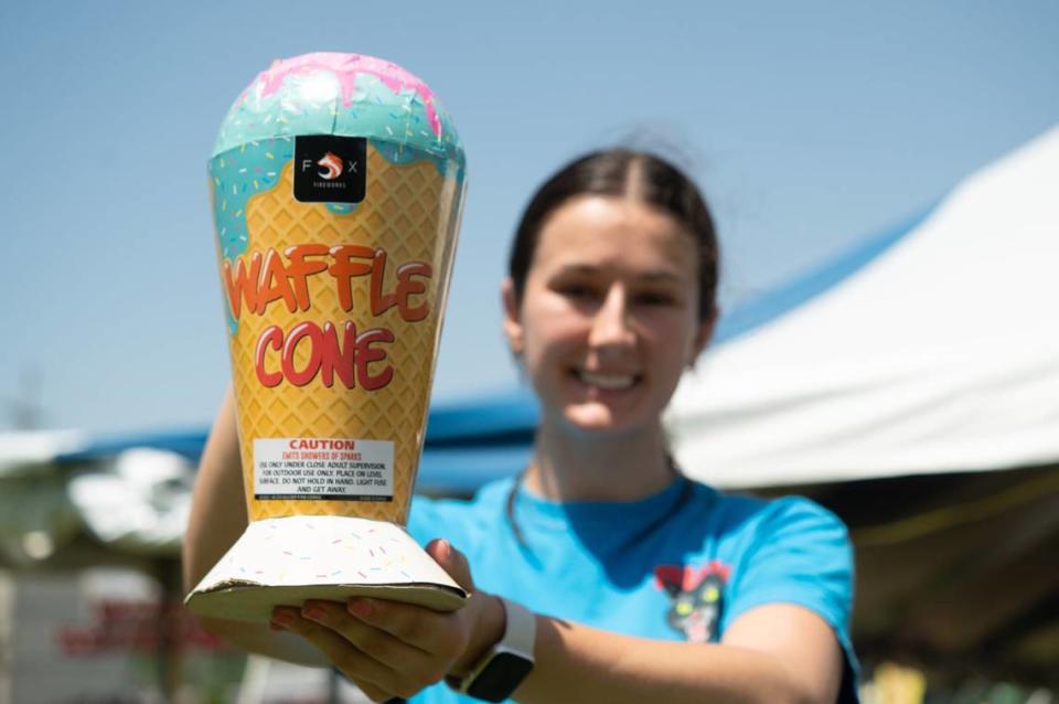 Paige Hunter displays a waffle cone fountain firework, which will produce a variety of colorful sparks, on Tuesday, July 2, 2024, at Pyro City Fireworks off Southwest Boulevard in Kansas City, Kansas. Shops and tents throughout Kansas City and surrounding areas offer a nearly unending selection of fireworks leading up to July 4, including many unique and outrageous varieties.