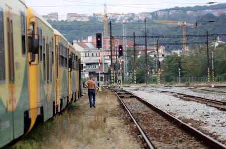 A man walks past a train at Bubny railway station in Prague