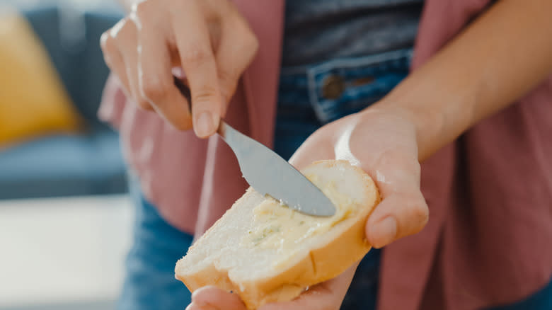 Woman buttering a piece of bread