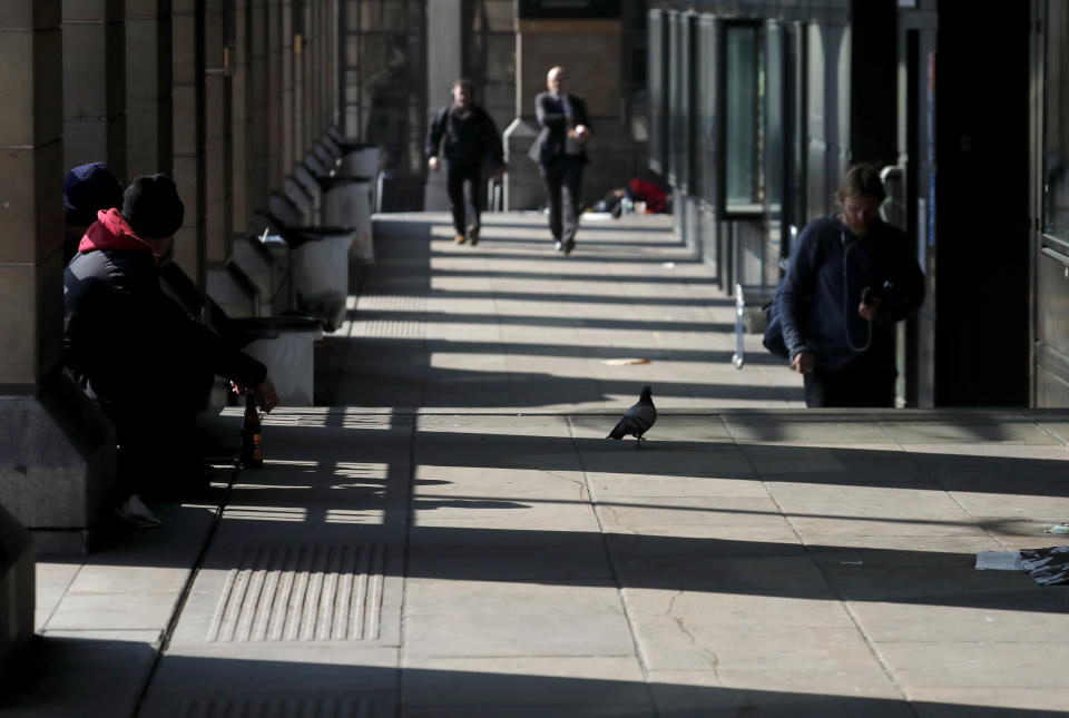 People shelter under a walkway in Westminster in London, British people have been told to stay home to prevent the spread of the new coronavirus, Friday, March 27, 2020. Local Authorities in England have been asked by the prime minister's homelessness advisor to house all homeless people by the weekend, to help stop the spread of COVID-19. (AP Photo/Frank Augstein)