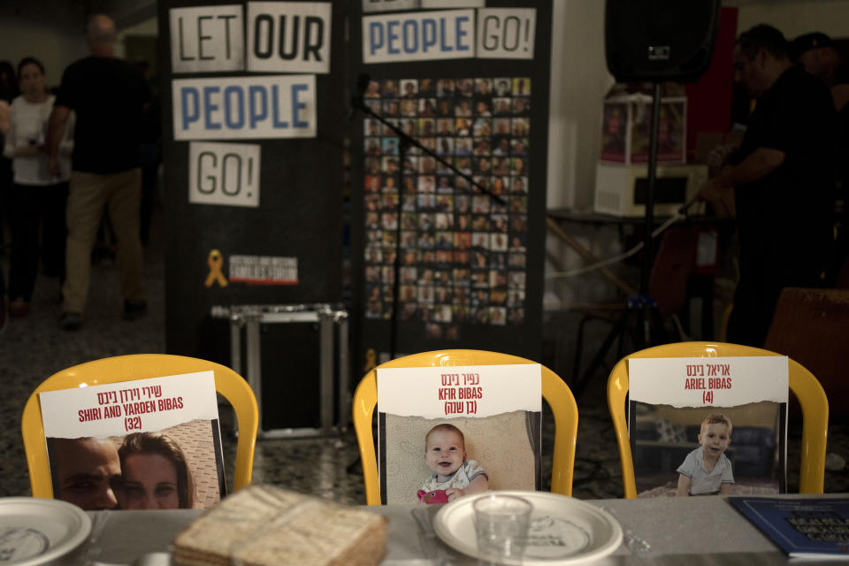 Chairs marked with images of the Bibas family, hostages held in Gaza, are placed at a Passover seder table, in the communal dining hall at Kibbutz Nir Oz in southern Israel, April 11, 2024. For many Jews, Passover is a time to unite with family to eat and drink around what's known as a Seder table. But this year, when Passover begins on Monday, many families are torn on how to celebrate. (AP Photo/Maya Alleruzzo)