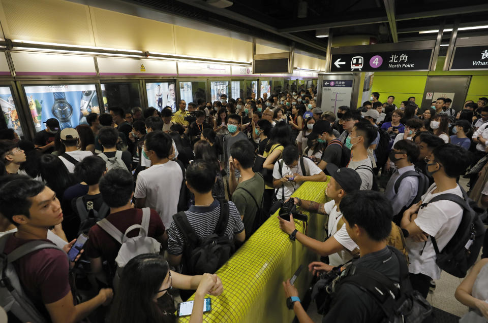 Passengers queue up at a subway platform in Hong Kong on Tuesday, July 30, 2019. Protesters in Hong Kong have disrupted subway service during the morning commute by blocking the doors on trains, preventing them from leaving the stations. (AP Photo/Vincent Yu)