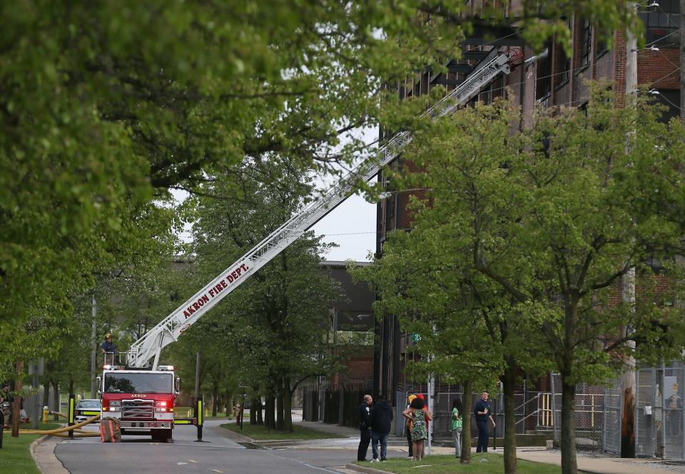 An Akron Fire Department ladder truck sprays water into window on Thursday as they battle a fire in an abandoned factory.