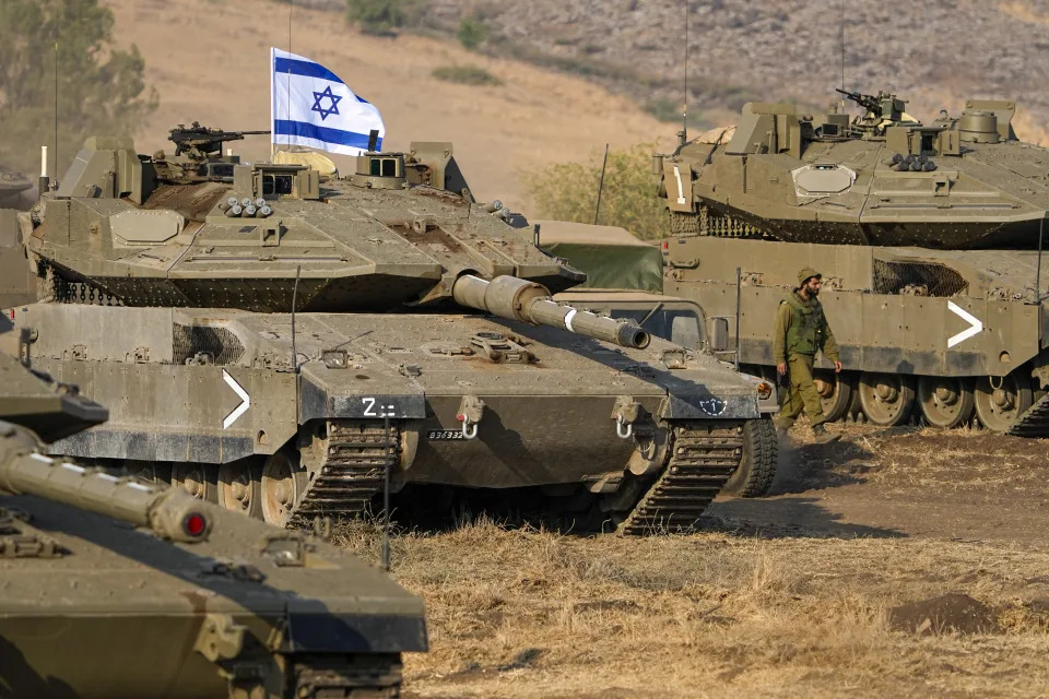 Israeli tanks are stationed near the border with Lebanon Wednesday, Oct. 11, 2023. An Israeli ground offensive in Gaza would further escalate the war raging since Hamas launched its unprecedented attack days ago. The United States already deployed one aircraft carrier group to the region, with another on the way. That reflects concerns of a widening conflict and is meant to deters Iran and others. (AP Photo/Ariel Schalit)