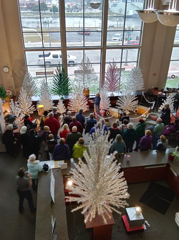 A group gathers to hear about the history of the Evergleam Aluminum tree.