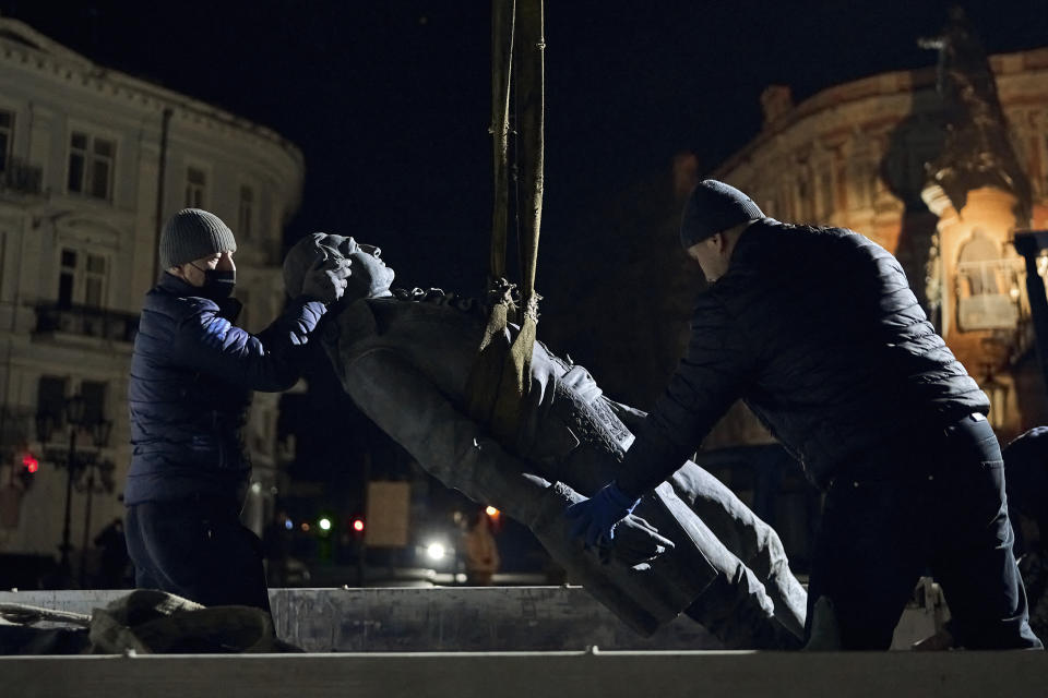 Workers remove part of the monument to Catherine II, also known as "Monument to the Founders of Odesa" in Odesa, Ukraine, late Wednesday, Dec. 28, 2022. The decision to dismantle the monument consisting of sculptures of Russian Empress Catherine II and her associates was made recently by Odesa residents by electronic voting. (AP Photo/LIBKOS)